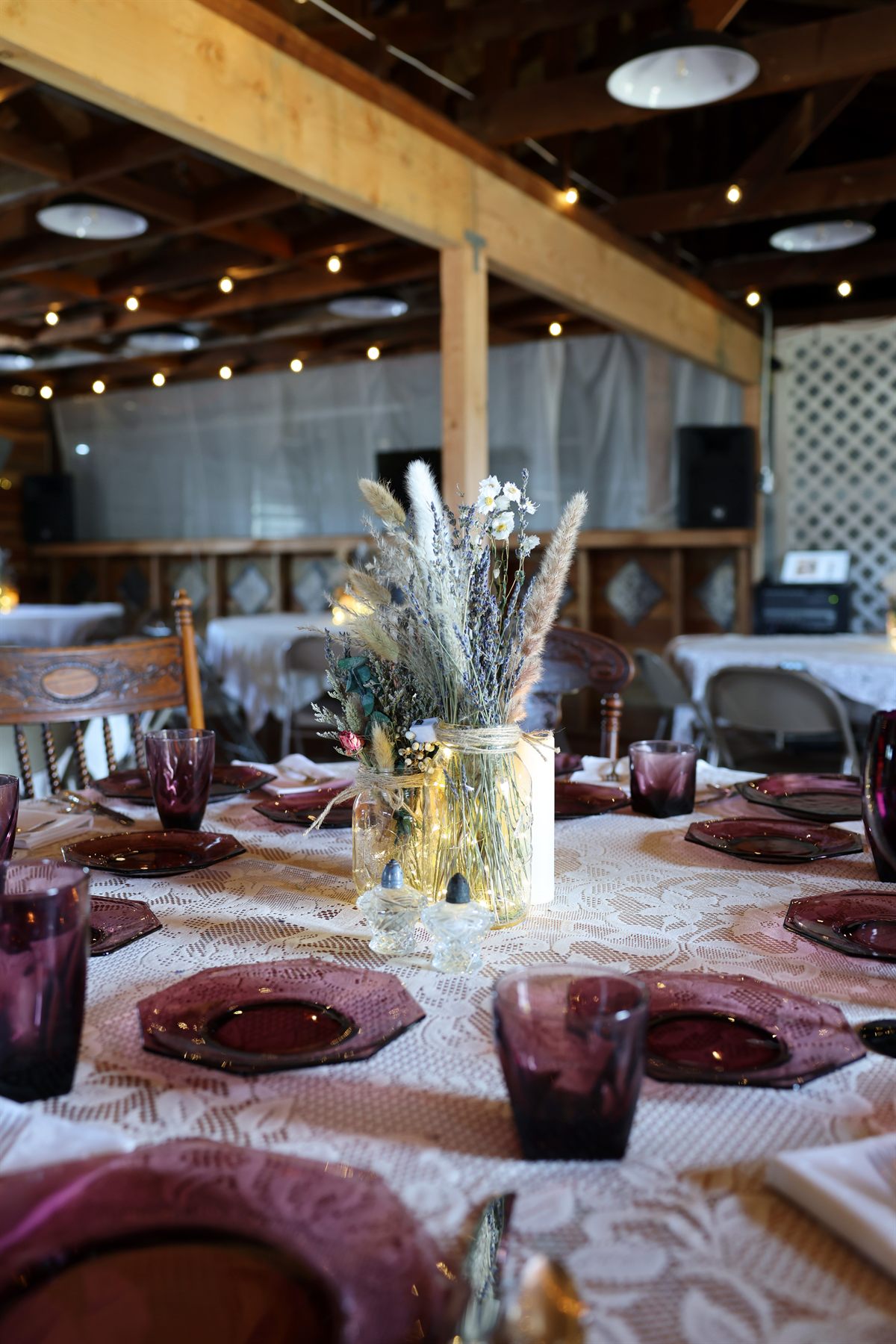 Rustic table setting with lace and floral centerpiece.